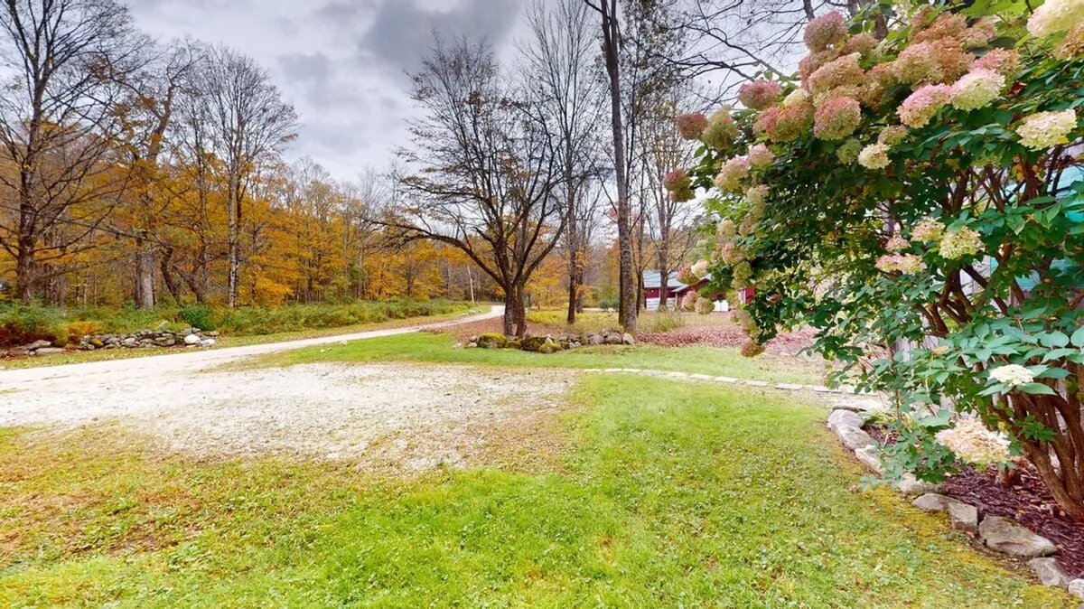 A serene outdoor scene featuring a gravel path meandering through colorful flowers and trees. The peaceful garden atmosphere is perfect for leisurely strolls, nature appreciation, and quiet moments of reflection.